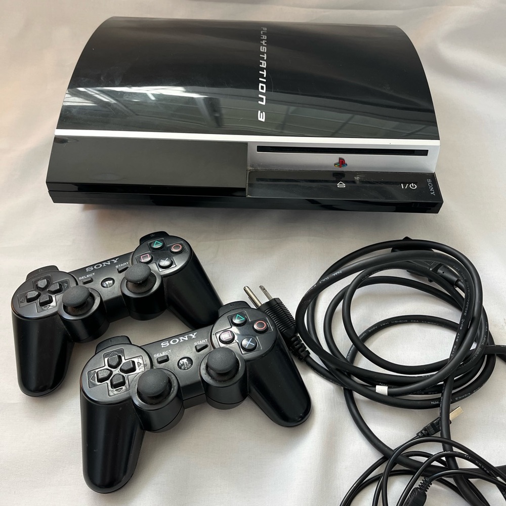 playstation 3 with 2 controllers and charging cable